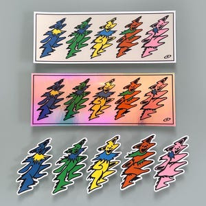 May include: Two rectangular stickers and five individual die-cut stickers featuring a repeating pattern of five dancing bears in blue, green, yellow, orange, and pink. The top sticker has a white background, while the second has a holographic finish.