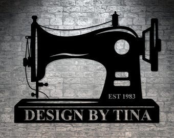 May include: Black metal silhouette of a sewing machine with the text "EST 1983" and "DESIGN BY TINA" on a brick wall background.