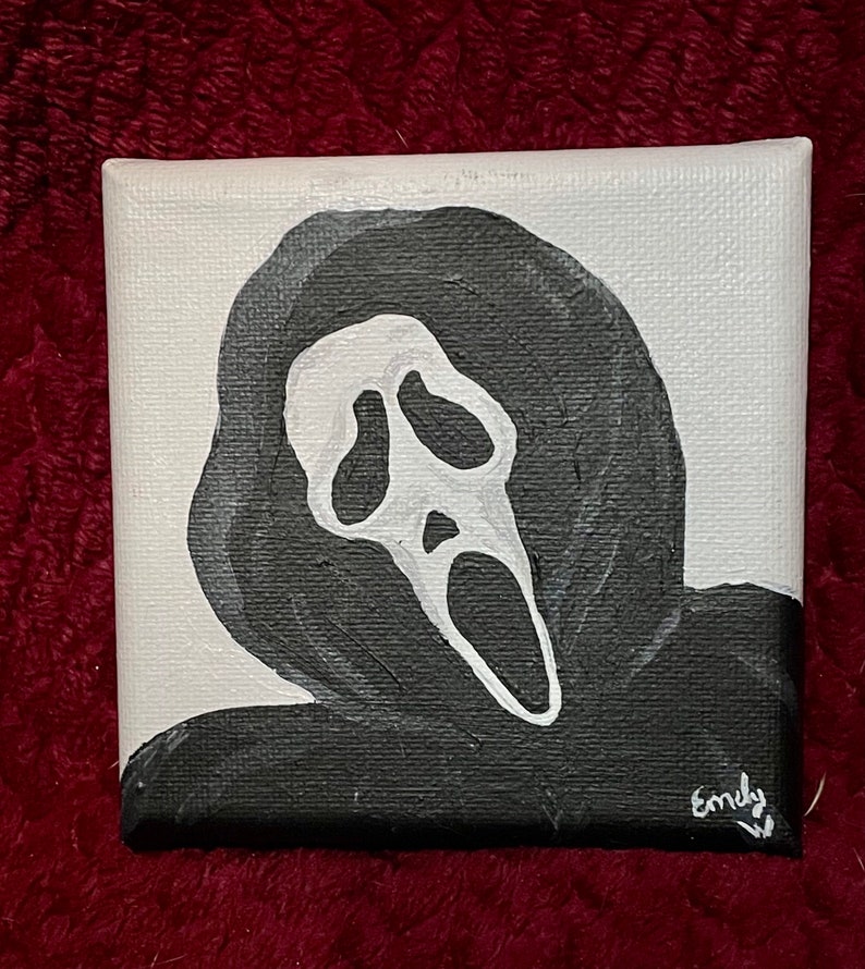 May include: A black and white painting of the Ghostface mask from the Scream film franchise. The mask is painted on a white canvas with black paint. The mask is a white silhouette with black eyes and a wide open mouth.