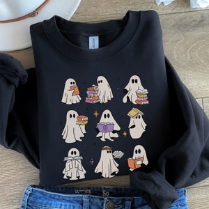 May include: Black sweatshirt featuring a design of nine ghosts reading books. The ghosts are white and have various expressions. The text "So Ultimate" is printed on the bottom of the sweatshirt.