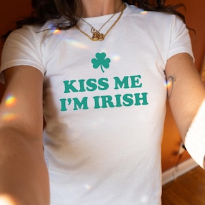 May include: White t-shirt with a green shamrock and the text "Kiss Me I'm Irish".
