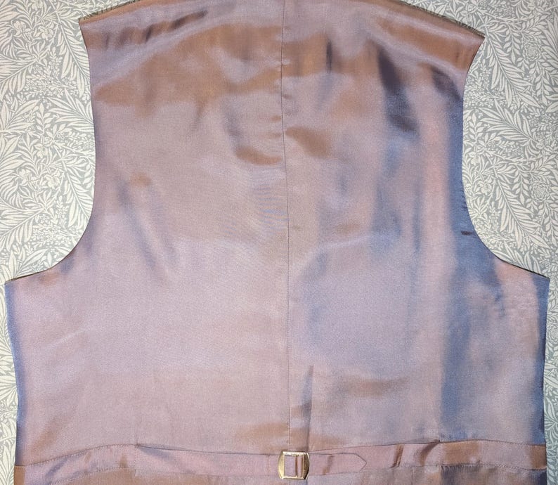 May include: A white ceramic mug with a black handle and the text "But First, Coffee" in a handwritten style. The mug is on a white surface. The mug is approximately 10 cm tall.