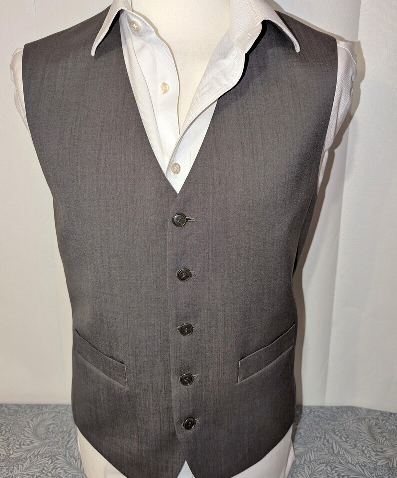 May include: A white ceramic mug with a black handle and the text "But First, Coffee" in a black, bold font. The mug is on a white surface.