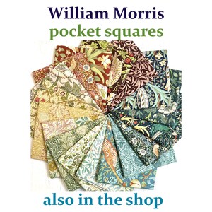 May include: A selection of William Morris pocket squares, fanned out to display their patterns. The squares showcase floral and leaf motifs in a range of colours, including green, red, and blue. Text reads "William Morris pocket squares" and "also in the shop".