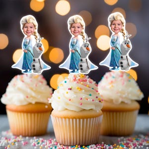May include: Three cupcakes with white frosting and colorful sprinkles topped with edible images of a girl dressed as Elsa from Frozen and Olaf the snowman.