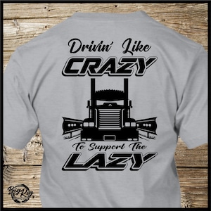 May include: Grey t-shirt with a black graphic of a semi-truck and the text "Drivin' Like Crazy To Support The Lazy".