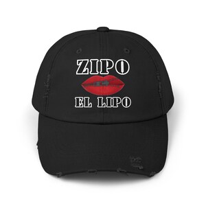 May include: Black distressed baseball cap with white text that reads "ZIPO EL LIPO" and a red mouth with a zipper.