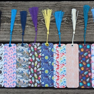 Puede incluir: Diez marcadores de colores con diferentes patrones, incluyendo estrellas, arcoíris, montañas, helados y veta de madera. Cada marcador tiene un borla en la parte superior.