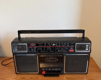 Radiocasete portátil General Electric de los años 90, modelo GE 3-5452, con reproductor de casetes y radio AM/FM.