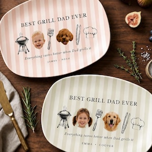 May include: Two oval plates with vertical stripes, one pink and one cream, each with "BEST GRILL DAD EVER" text. The plates feature illustrations of a grill, chef's hat, and faces, with the text "Everything tastes better when Dad grills it."