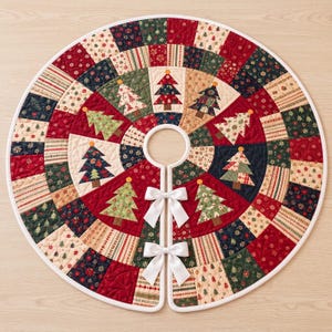 May include: A circular quilted Christmas tree skirt featuring a patchwork design of red, green, cream, and navy blue fabric squares. The pattern includes various holiday motifs like small trees and stars, with two white satin bows at the opening.