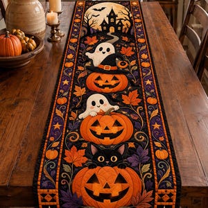 Peut inclure: Un chemin de table matelassé rectangulaire sur le thème d'Halloween avec un fond noir, des citrouilles orange, des fantômes blancs, un chat noir et des feuilles d'automne. Le motif inclut une silhouette de maison hantée sous une pleine lune.