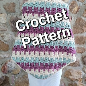 Puede incluir: Un patrón de ganchillo para una chal o una envoltura en tonos de rosa, crema y turquesa. El patrón se muestra en un maniquí.