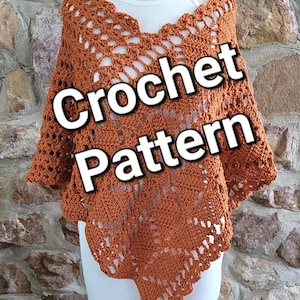 Puede incluir: Patrón de ganchillo para un poncho de color óxido con un diseño de encaje. El poncho se muestra en un maniquí blanco contra una pared de piedra.