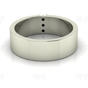 Puede incluir: Un anillo de banda de plata con tres piedras preciosas negras engastadas en una fila en la parte superior de la banda.