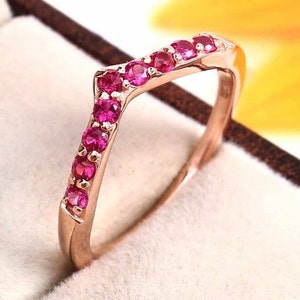 Könnte beinhalten: Ein Ring aus Roségold mit einem Chevron-Design, besetzt mit rosafarbenen Edelsteinen.
