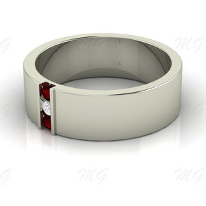 Puede incluir: Un anillo de banda de plata con una fila de tres piedras preciosas rojas y una sola piedra blanca en el centro.