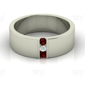 Puede incluir: Un anillo de banda de plata con tres piedras engastadas en fila. Las piedras son rojas y blancas.