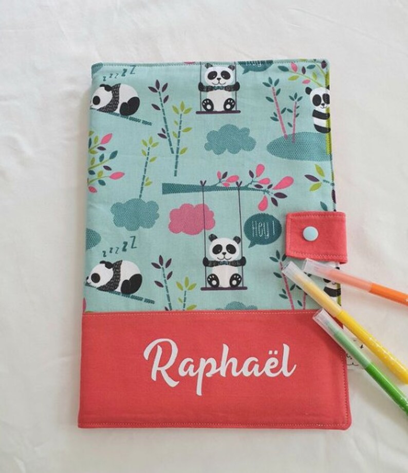 Puede incluir: Una funda de tela turquesa con un estampado de osos panda y el nombre "Rapha&euml;l" en blanco. La funda tiene una solapa de color coral con cierre de bot&oacute;n y contiene varios rotuladores de colores. El dise&ntilde;o de panda incluye pandas en columpios y pandas durmiendo.