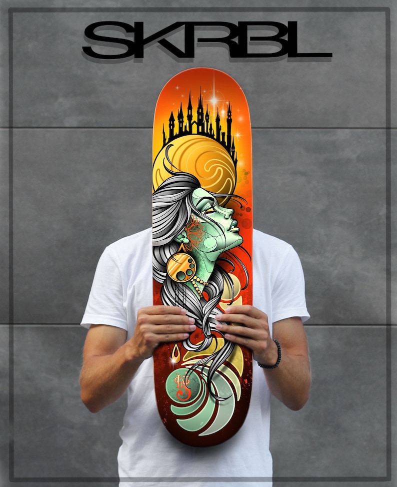 Pu&ograve; includere: Un deck da skateboard con un'illustrazione colorata di un viso di donna con una corona di castelli sopra la sua testa. Lo sfondo &egrave; un tramonto con un motivo a spirale. Il testo "SKRBL" &egrave; stampato nella parte superiore del deck.