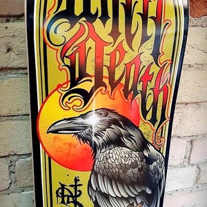May include: A yellow and black skateboard deck with a graphic of a raven, a rose, and a skull. The text "Grim Death" is written in a stylized font.