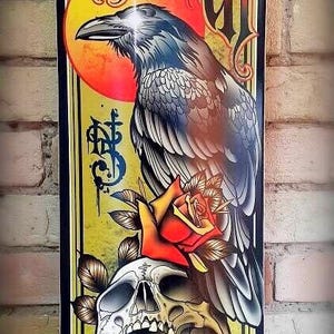 May include: A yellow and black skateboard deck with a skull and rose design. The words "Till Death" are written in a gothic font at the top of the deck.