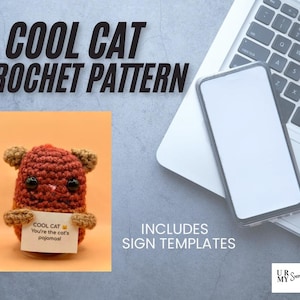 May include: A crocheted cat pattern with the text "COOL CAT CROCHET PATTERN". The cat is brown with tan ears and paws, holding a sign that reads "COOL CAT You're the cat's pajamas!". Includes sign templates.
