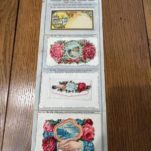 May include: A vintage pocket sample case from the Ohio Card Company, featuring various designs. The case includes samples of visiting cards, stationery, and scrap pictures. The designs include floral arrangements and landscape scenes.