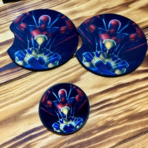 Puede incluir: Dos posavasos redondos negros con un gr&aacute;fico de Deadpool y Wolverine. Los posavasos presentan un esquema de color rojo y negro con un acento amarillo y azul. El tercer posavasos es un posavasos redondo negro m&aacute;s peque&ntilde;o con el mismo gr&aacute;fico.
