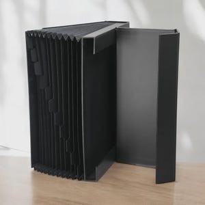 May include: A black accordion file folder with multiple labeled sections. The file folder is made of a rigid material and has a rectangular shape. The file folder is designed to hold documents and papers.