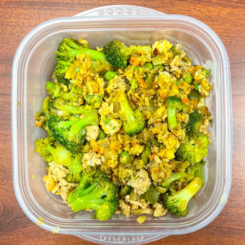 Peut inclure: Un r&eacute;cipient en plastique transparent rempli d'un plat de saut&eacute;. Le plat contient des bouquets de brocoli hach&eacute;s, des &oelig;ufs brouill&eacute;s et d'autres l&eacute;gumes.