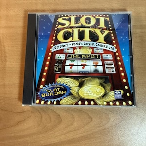 以下が含まれることがあります： カジノをテーマにしたSlot City CDケース。カバーには「JACKPOT」の文字と「120 Slots - World's Largest Collection！」のテキストが表示されたスロットマシンが描かれています。CDケースは黒いプラスチックケースに入っています。