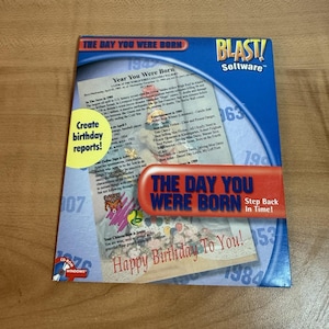Op de afbeelding: Een blauwe softwarebox met de titel "The Day You Were Born" met het "BLAST! Software" logo. De doos bevat tekst over verjaardagen, waaronder "Maak verjaardagsrapporten!" en "Gelukkige verjaardag voor jou!"