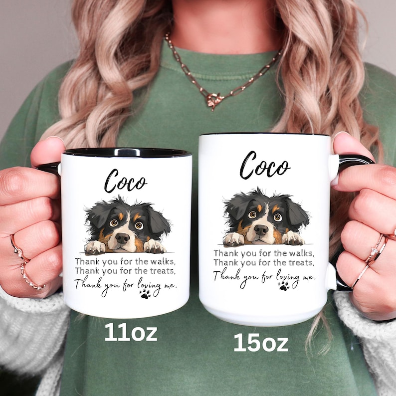 May include: Two white ceramic mugs with black interiors and handles. Each mug features a black and brown dog illustration, the name Coco, and the text: Thank you for the walks, Thank you for the treats, Thank you for loving me. One is 11oz, one is 15oz.