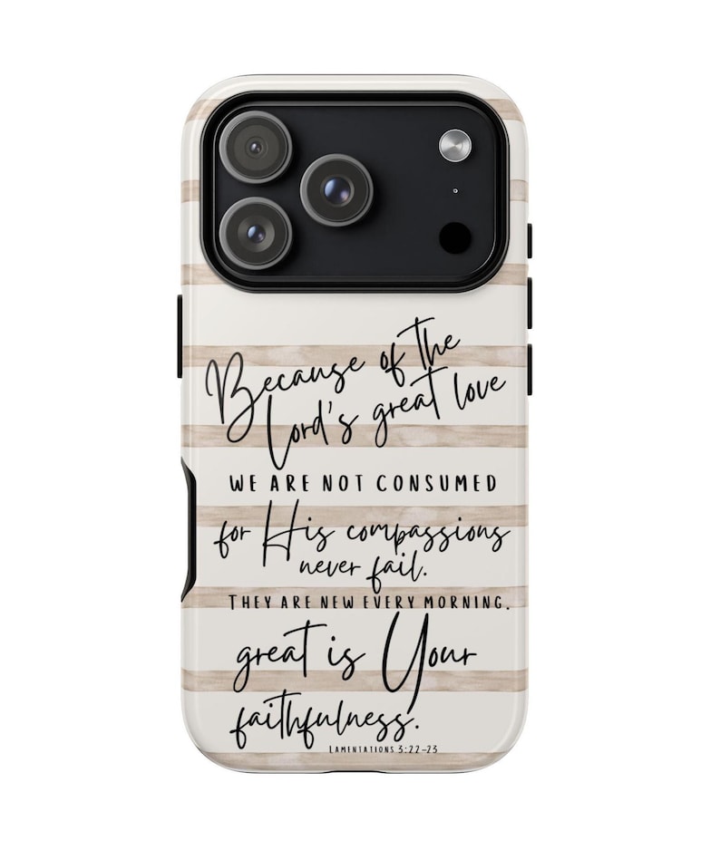 May include: A phone case with a cream and tan striped design. The case features the text "Because of the Lord's great love...great is Your faithfulness." The case has a black camera module with three lenses.