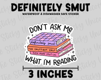 May include: A sticker with the text "DEFINITELY SMUT" and "WATERPROOF & DISHWASHER SAFE STICKER". The sticker features a stack of books with the phrases "DON'T ASK ME WHAT I'M READING", "definitely smut", "THE SMUTTIEST SMUT", and "EVEN MORE SMUT LOL". The sticker is 3 inches wide.