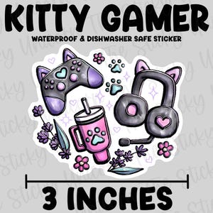 May include: A 3-inch waterproof sticker featuring a cartoon kitty gamer with a purple and black controller, pink headphones, and a pink cup with a paw print. The sticker is surrounded by pink flowers and lavender.