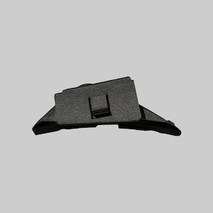 Può includere: Una staffa di montaggio per portapacchi auto in plastica nera con finitura superficiale testurizzata, una fessura rettangolare centrale e supporti laterali angolati progettati per un fissaggio sicuro al tetto del veicolo.