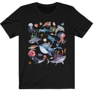 May include: Black t-shirt with a colorful watercolor design of various sea creatures, including a whale, shark, octopus, sea turtle, and starfish.