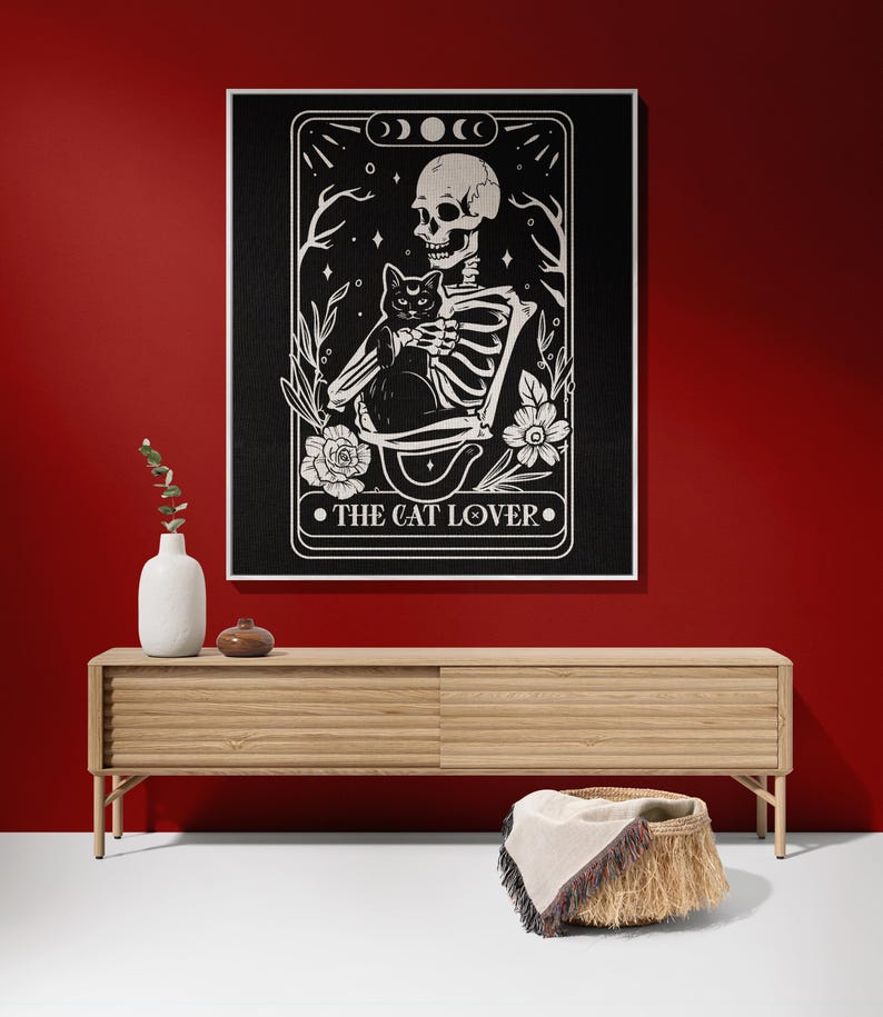 Puede incluir: Ilustraci&oacute;n en blanco y negro de un esqueleto sosteniendo un gato negro. La imagen est&aacute; enmarcada en un borde negro con el texto "The Cat Lover" en la parte inferior.