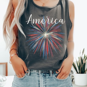 May include: A dark gray tank top with a white graphic of fireworks and the word "America" printed on the front.