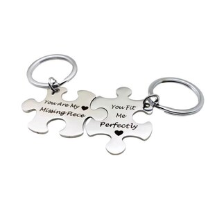 May include: Two silver puzzle piece keychains with the text "You Are My Missing Piece" and "You Fit Me Perfectly" engraved on them. Each piece has a small heart symbol.