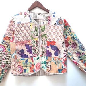 May include: A patchwork jacket with a variety of floral and patterned fabric panels. The jacket has a striped lining and a button closure. The colour palette includes pink, blue, green, and beige.