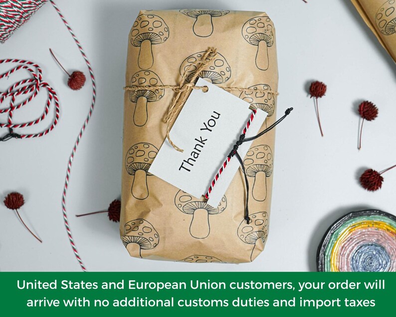 May include: A rectangular package wrapped in light brown paper featuring a repeating black line drawing of mushrooms. The package is tied with thin jute twine and includes a white rectangular gift tag with the black printed text Thank You.