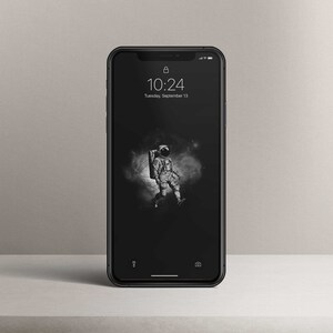 May include: A black smartphone with a lock icon and the time 10:24 displayed on the screen. The date is Tuesday, September 13. The background image is a black and white illustration of an astronaut walking in space.