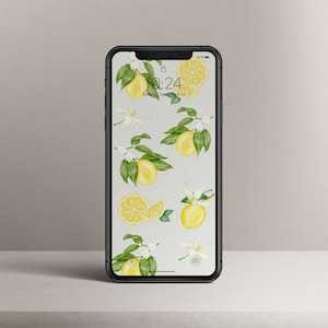 May include: A smartphone with a white background and a lemon-themed wallpaper. The wallpaper features yellow lemons, green leaves, and white flowers. The time on the phone is 10:24.