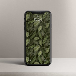 Könnte beinhalten: Ein schwarzes Smartphone mit einer grünen und braunen Tapetenmuster aus Kiefernnadeln. Die Uhrzeit ist 10:24 Uhr und das Datum ist Dienstag, der 13. September.