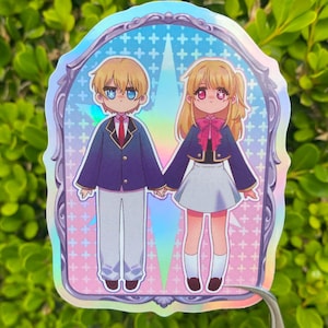 May include: Holographic sticker featuring two anime-style characters holding hands. The boy wears a blue blazer, white pants, and a red tie. The girl wears a blue jacket, white skirt, and a pink bow. The background is a pastel design.
