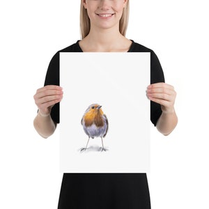 May include: A watercolor painting of a robin bird with a red breast, gray wings, and a yellow beak. The bird is standing on a white background.