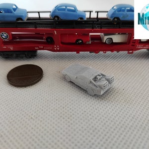 Puede incluir: Un coche modelo gris, que se asemeja a la m&aacute;quina del tiempo DeLorean de la pel&iacute;cula Regreso al futuro, est&aacute; sentado sobre una superficie blanca. El coche est&aacute; en una escala en miniatura y tiene un dise&ntilde;o detallado.